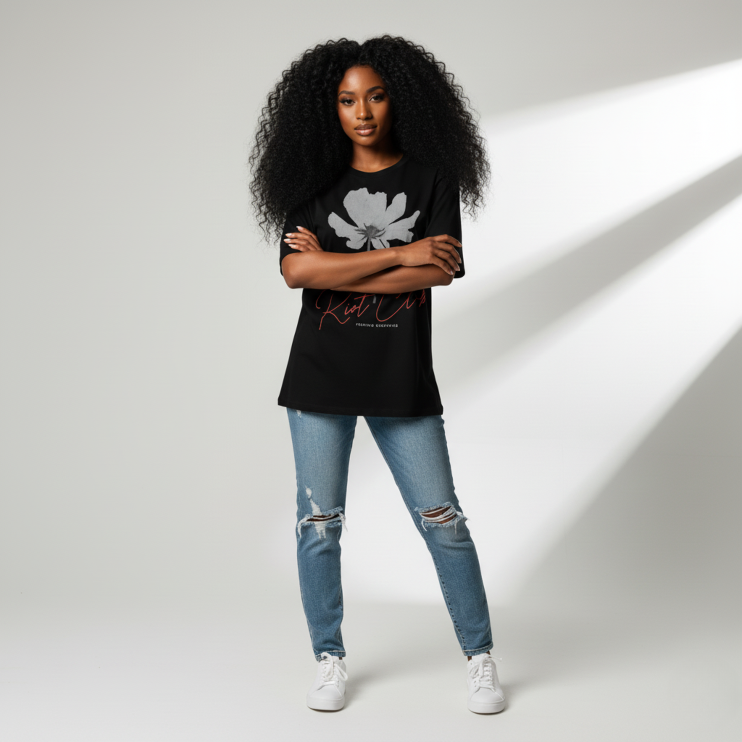 Woman wearing a black t-shirt with a graphic design and text, standing against a plain background