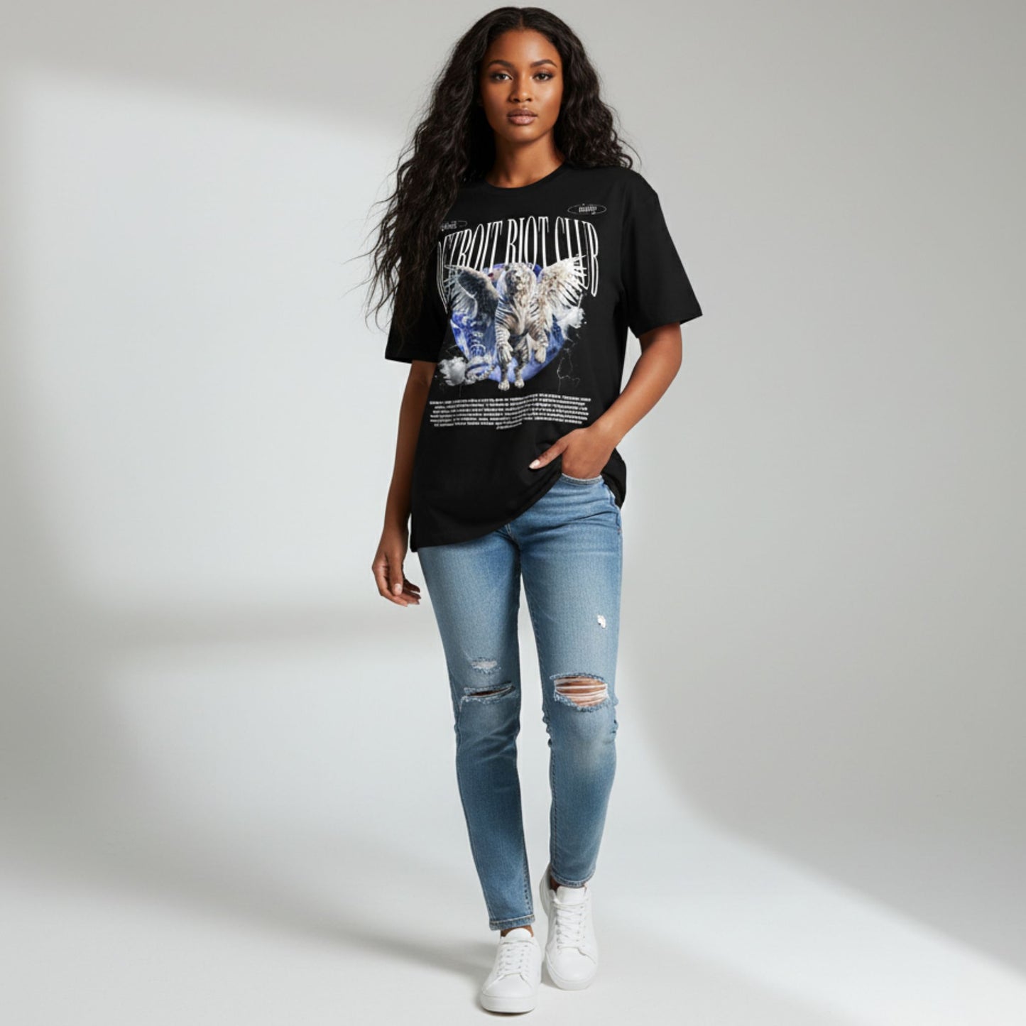 Woman wearing a black graphic t-shirt and blue jeans on a white background